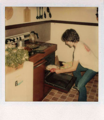 Antique photo of a person putting a dish in the oven